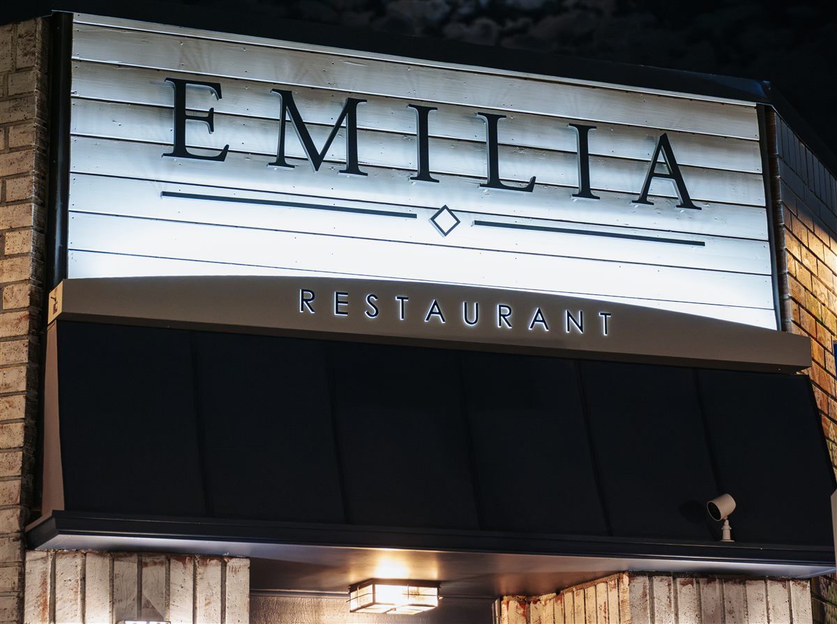 E M I L I A storefront sign at night
